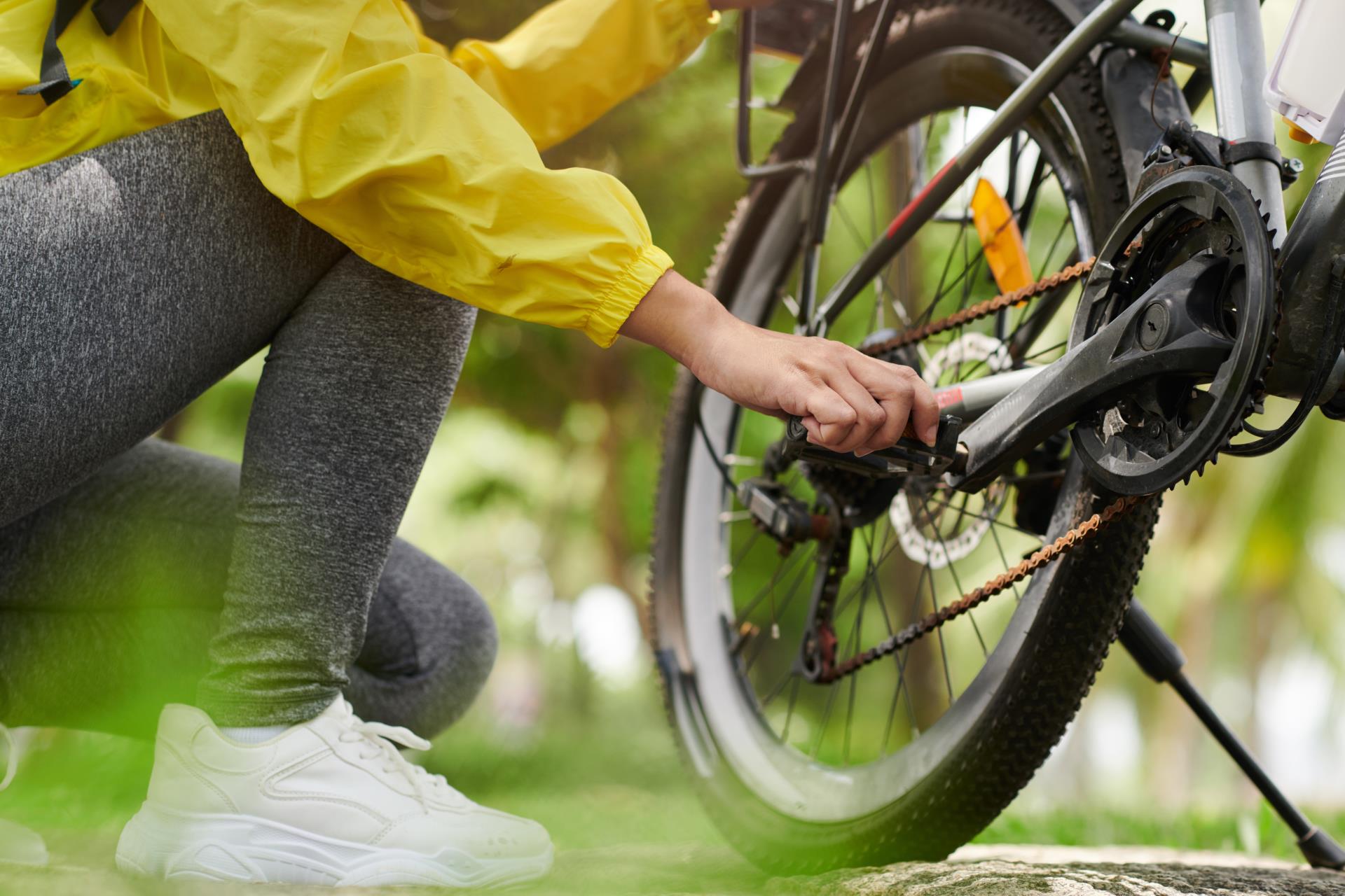 person checking the chain on a push bike