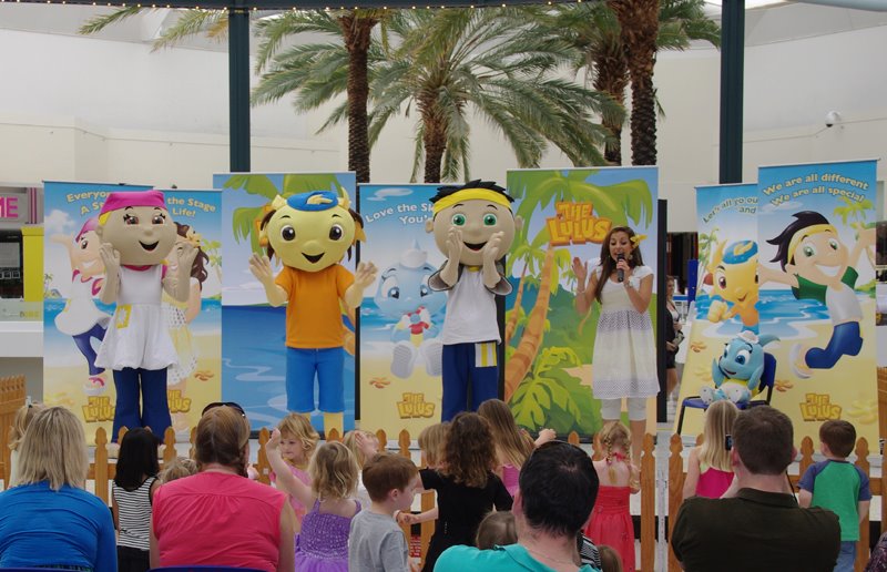 LuLus performers on stage, audience of adults and children