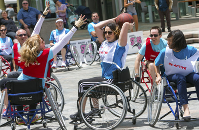 adults playing wheelchair basketball on an outdoor court