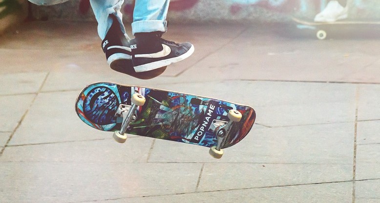 skater doing trick that shows the underside of the skateboard